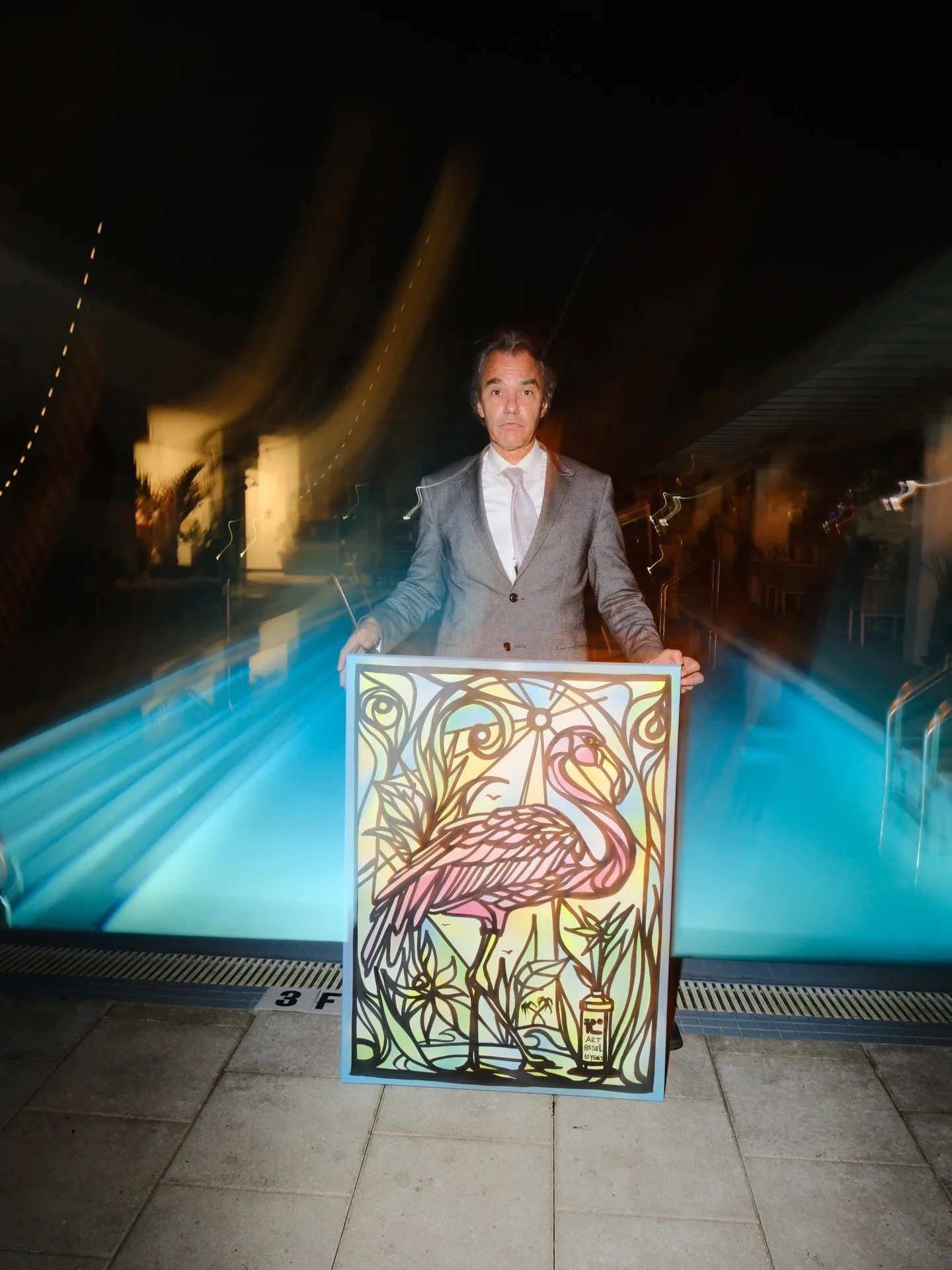 Guest with a flamingo painting beside the pool
