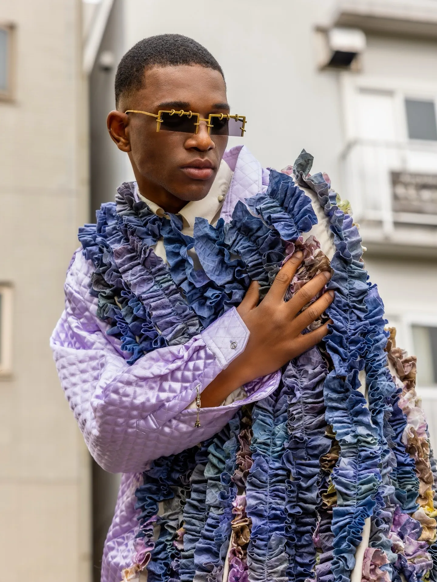Travon Ridley-Evans holding the ruffle stole, lilac quilted jacket